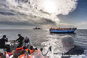 難民と移民で埋め尽くされたボートを地中海で救助したイタリア海軍