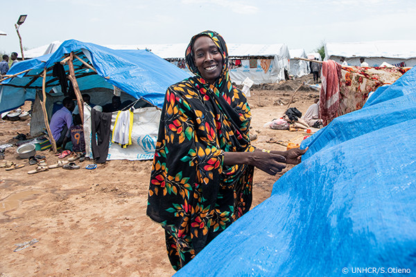 UNHCR職員から救援物資を受け取る人々