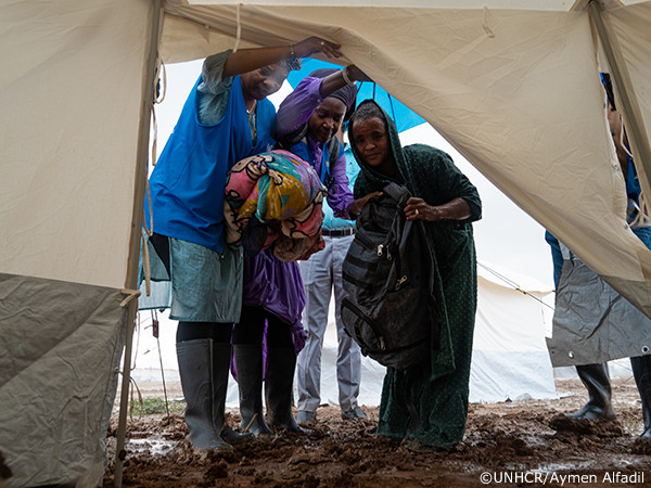 人々をシェルターに案内するUNHCRスタッフ